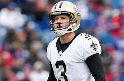 A football player wearing a helmet is standing on the field.