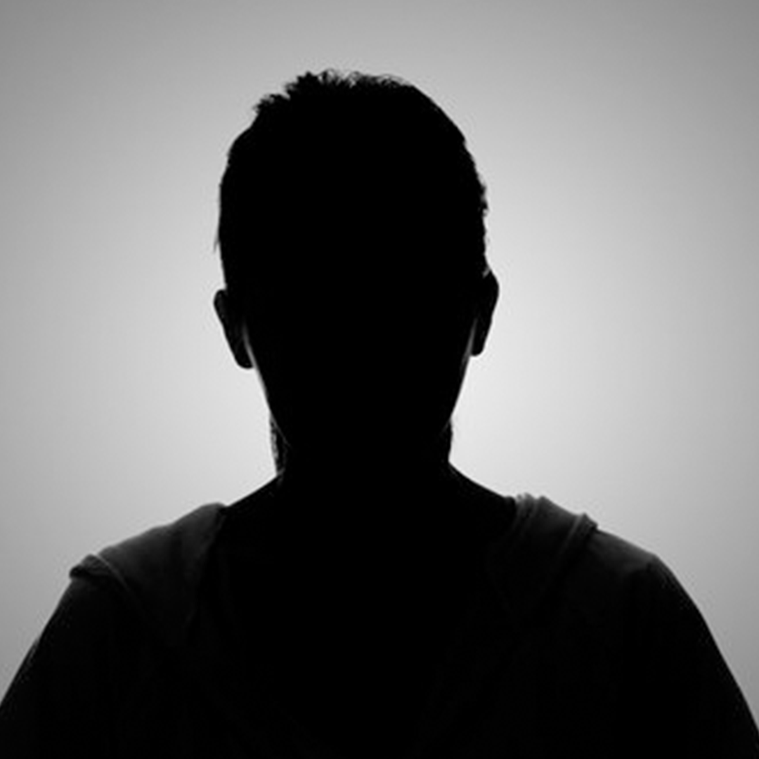 A silhouette of a man 's back is shown in a black and white photo.