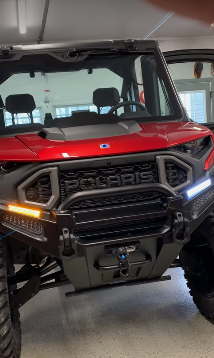 A red polaris ranger is parked in a garage.