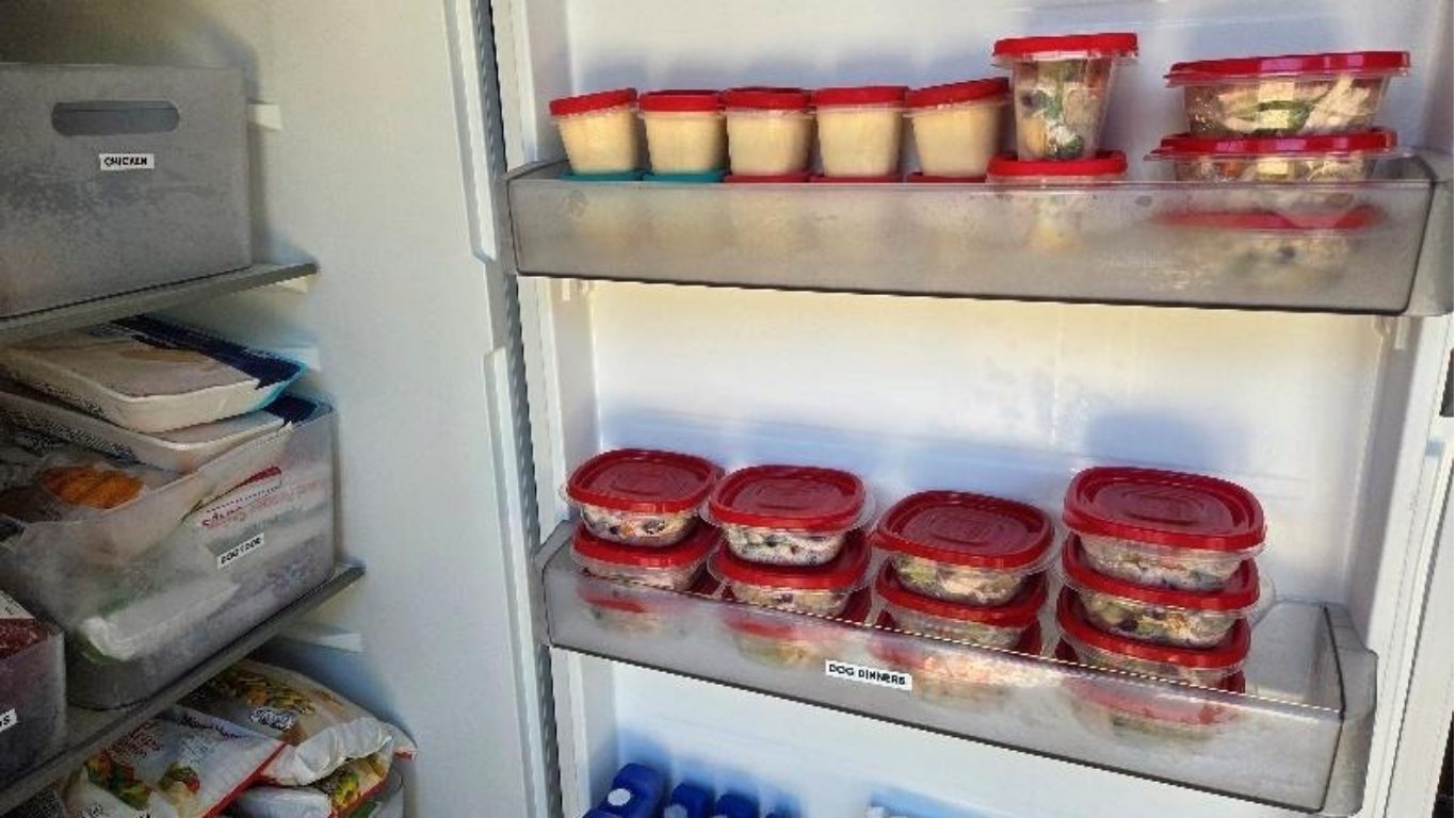 Open refrigerator shelves filled with multiple stacked tubs of red-labeled ice cream.
