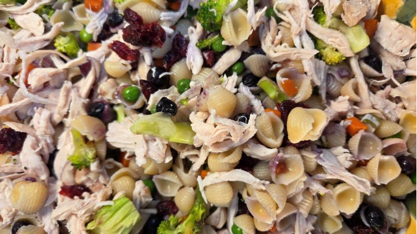 Mixed shell pasta salad with chicken, vegetables, and dark beans in a creamy dressing