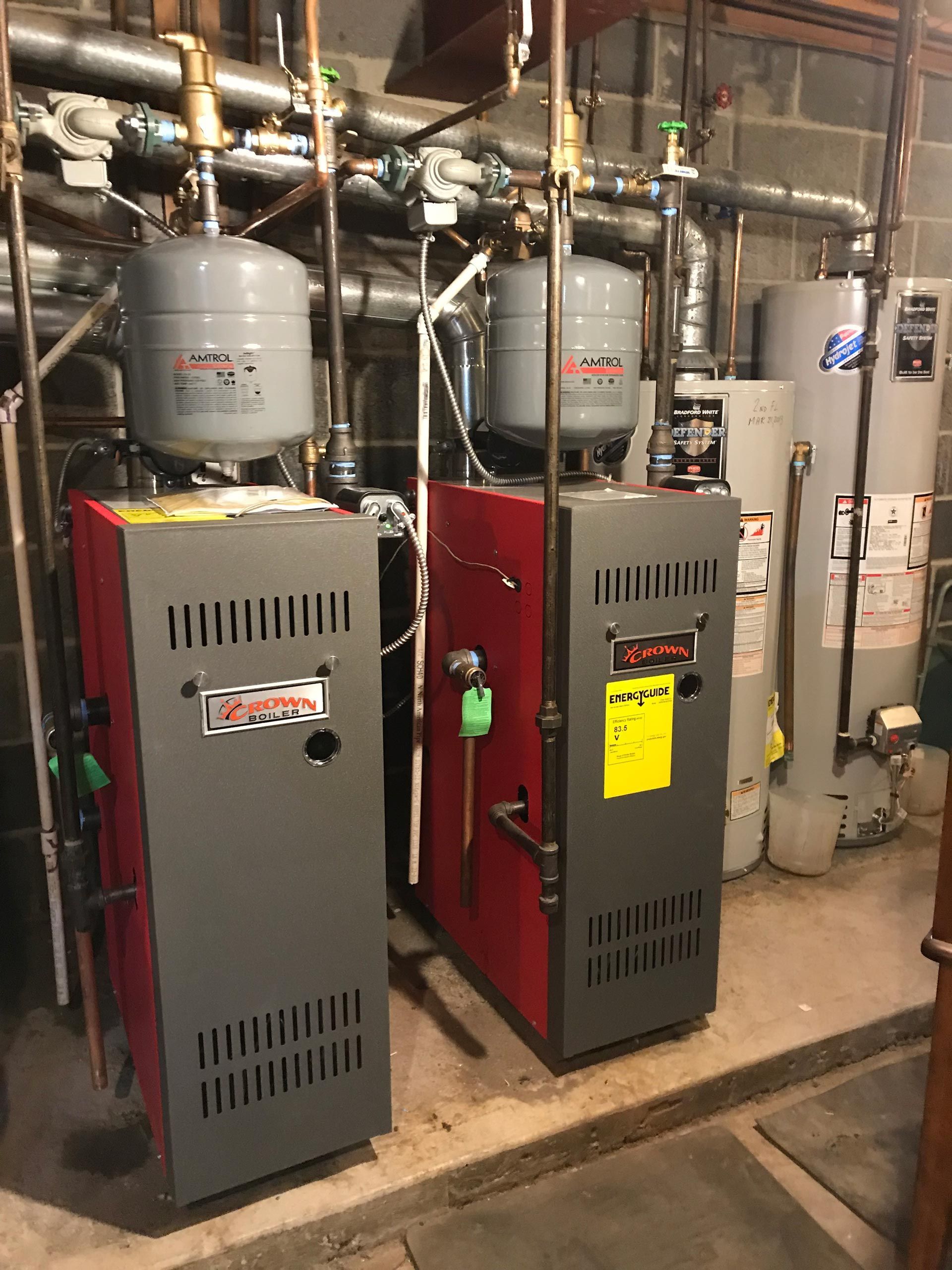 Two boilers are sitting next to each other in a room.