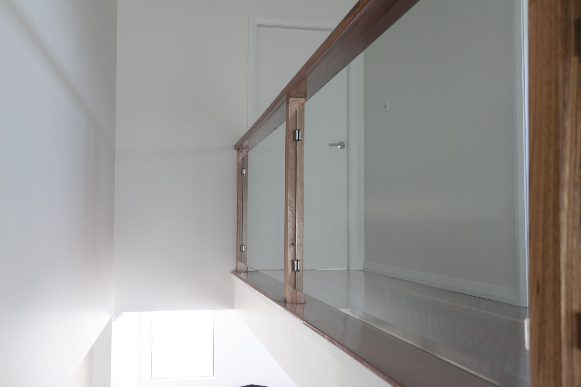 Glass Balustrade On Wooden Stairs Leading to A Brick Home — Waratah Home Improvements in Coledale, NSW