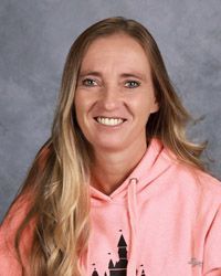 A woman in a pink hoodie is smiling for the camera.