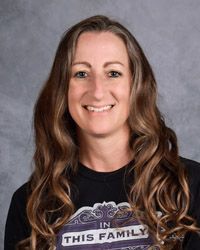 A woman with long hair is wearing a black shirt that says `` in this family ''.