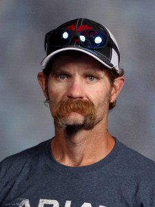 A man with a mustache is wearing a hat and sunglasses.