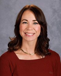 A woman wearing a red shirt is smiling for the camera.