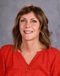 A woman wearing a red shirt is smiling for the camera.