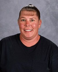 A woman in a black t-shirt is smiling for the camera.