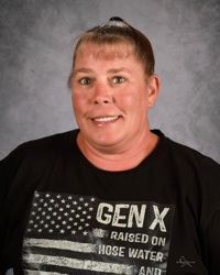 Smiling person in a black GEN X T-shirt against a gray studio backdrop