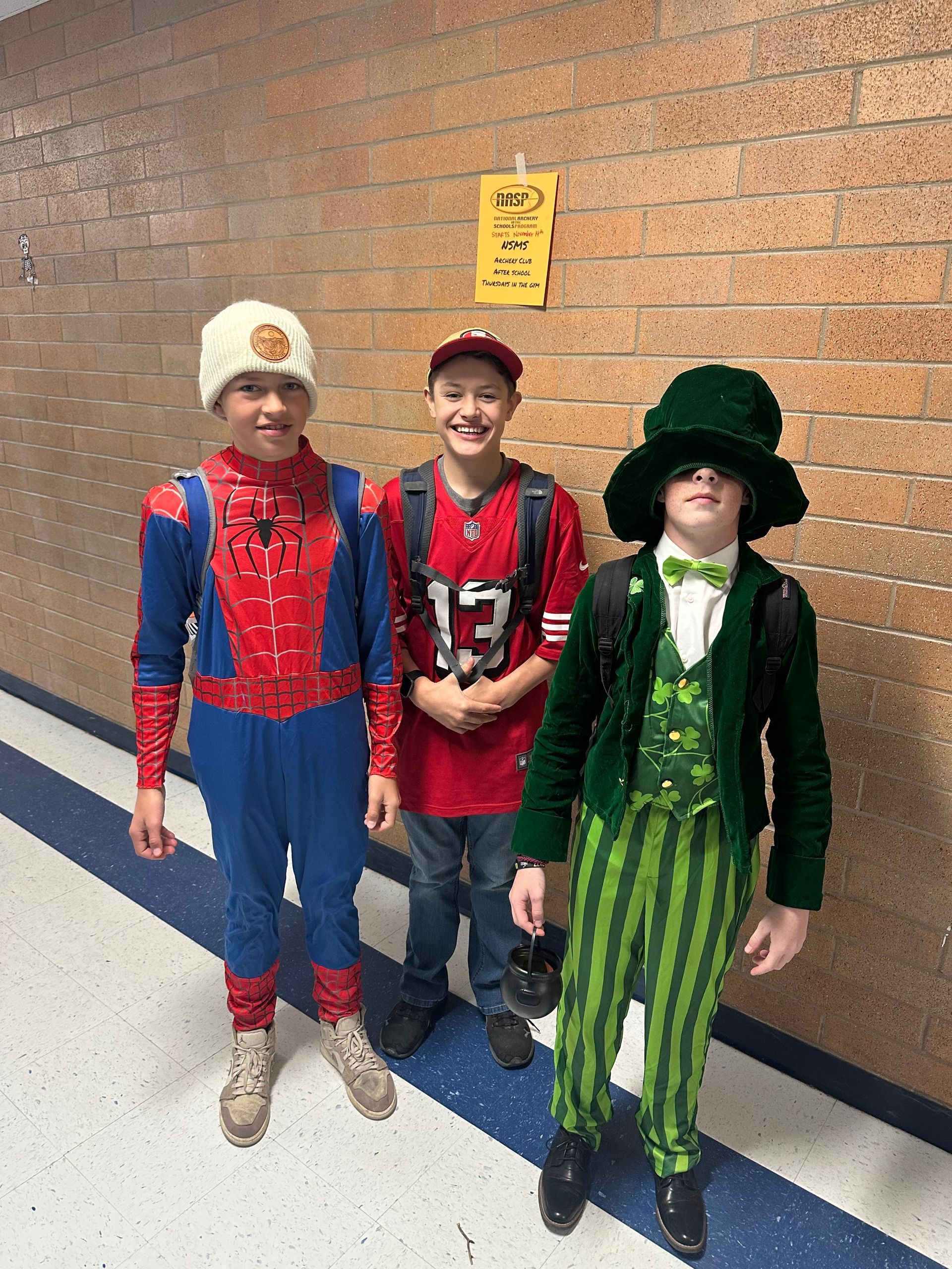 three students in hall dressed up for Halloween 
