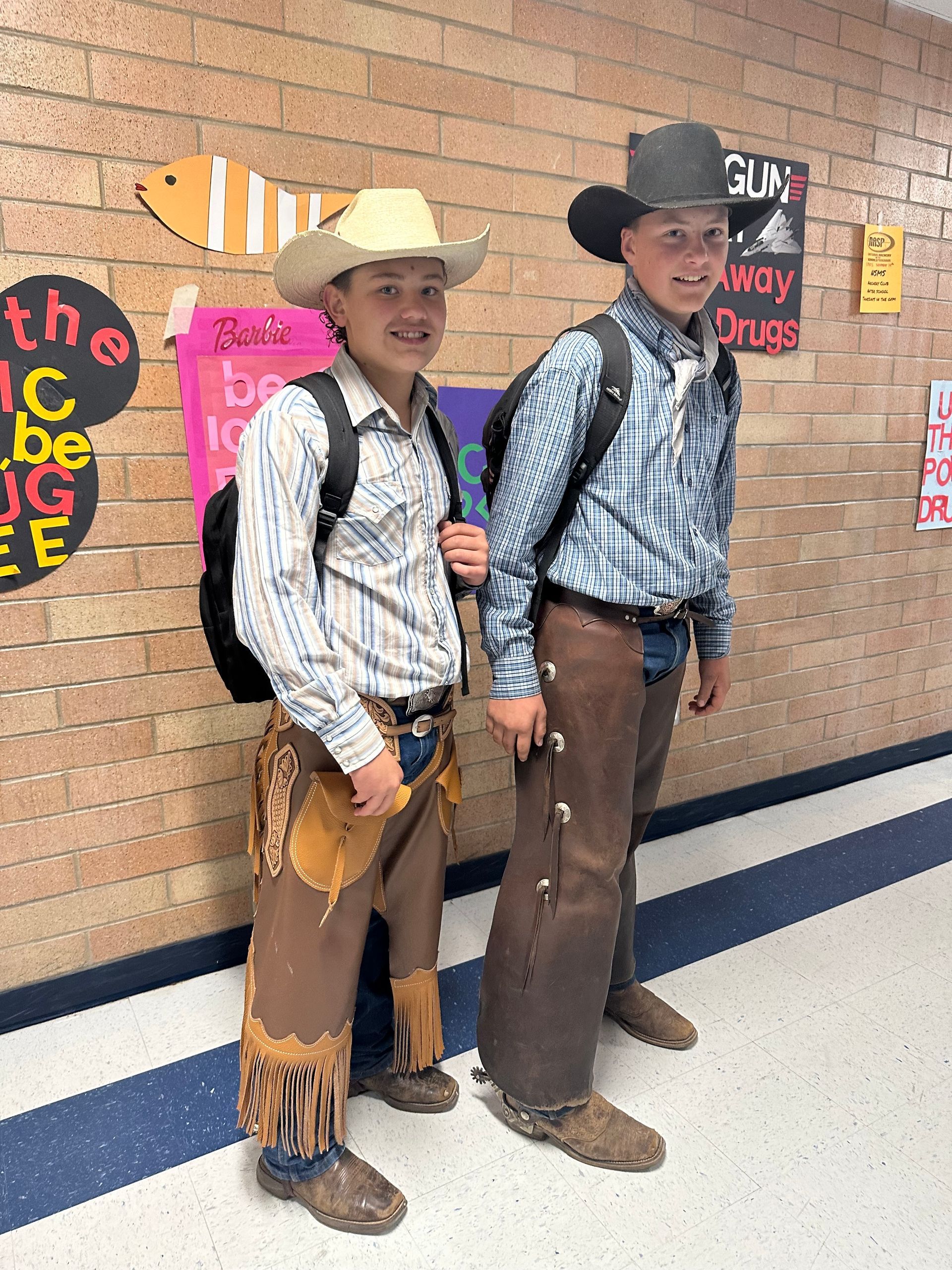 Two students standing in a hallway with real spurs on