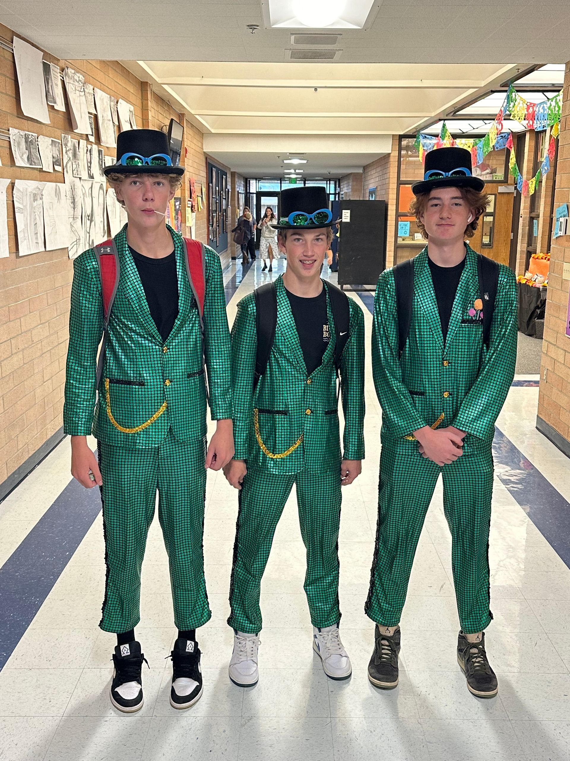 three students dressed in green for Halloween