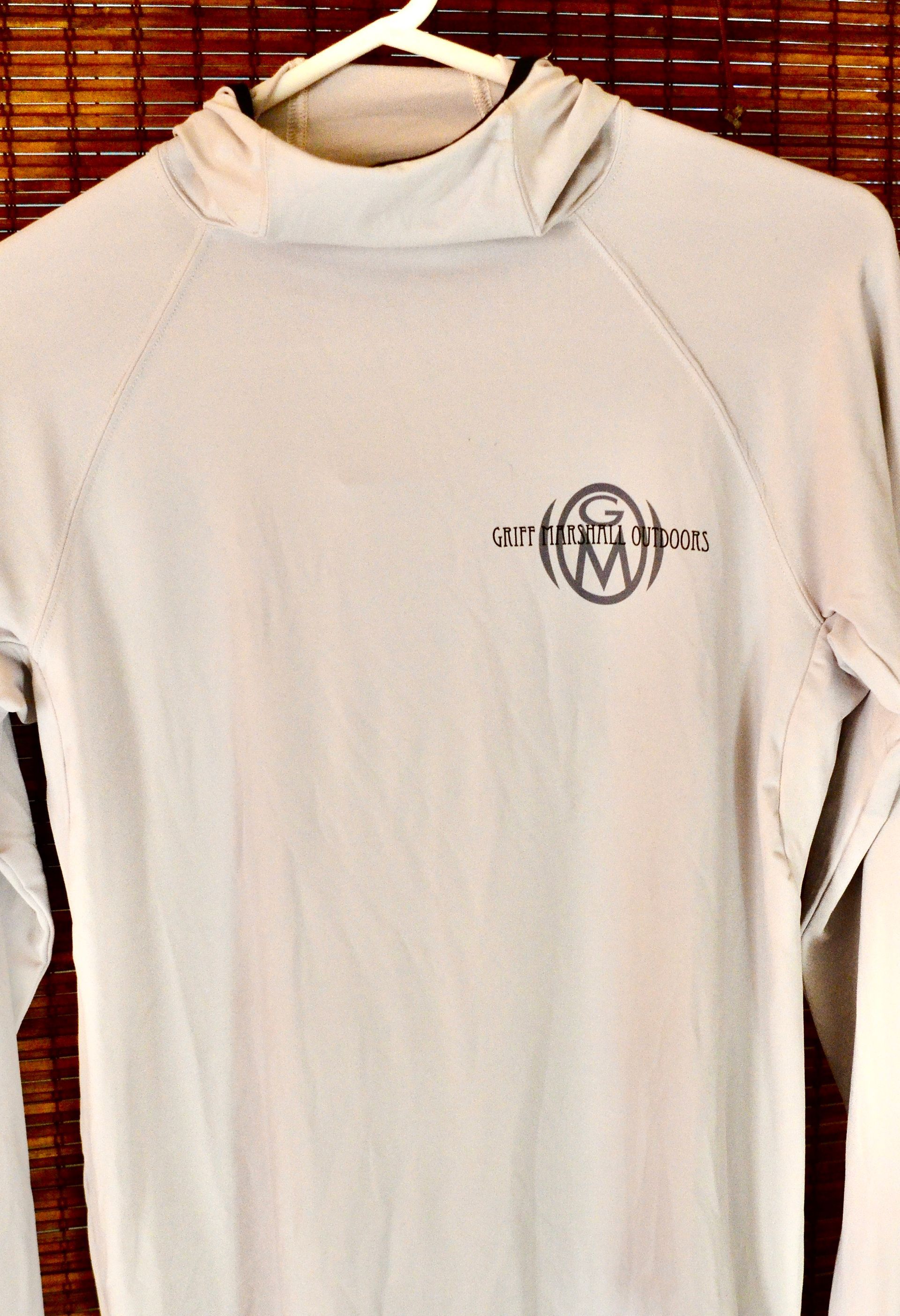 A white shirt with a hood is hanging on a hanger