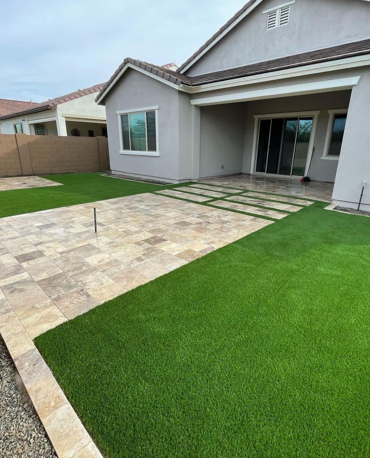 A house with a patio and a lawn in front of it.