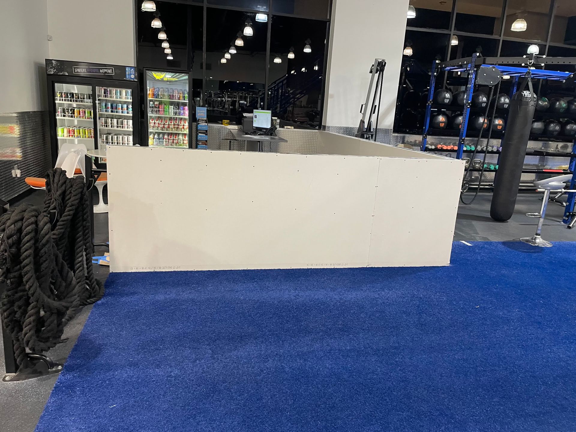 A gym with a blue rug and a white counter.