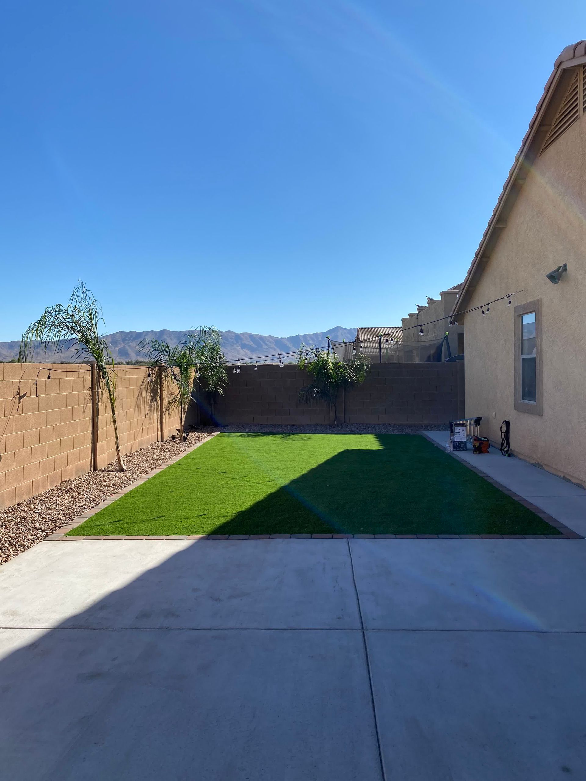 A backyard of a house with a lush green lawn