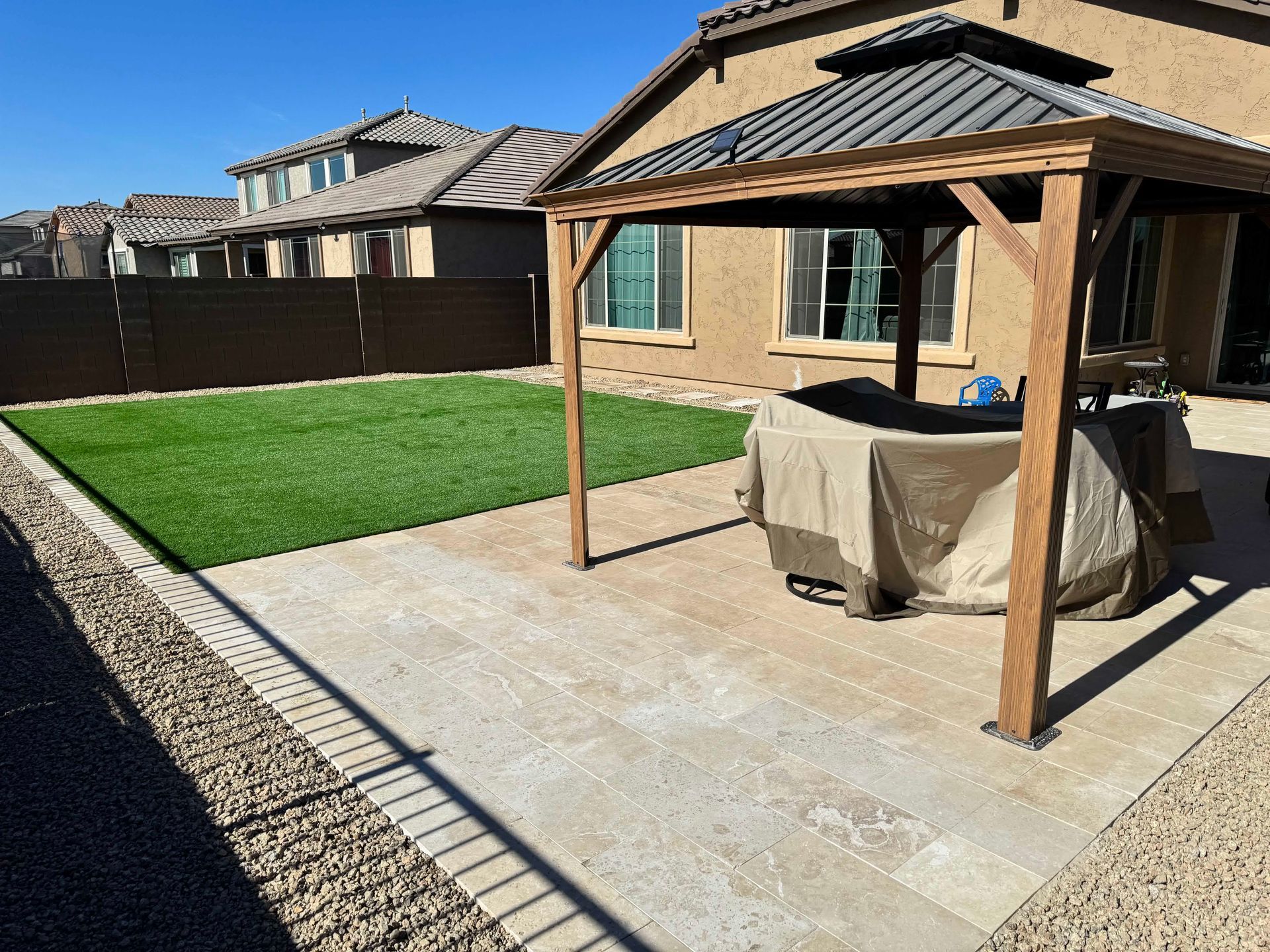 There is a gazebo in the backyard of a house.