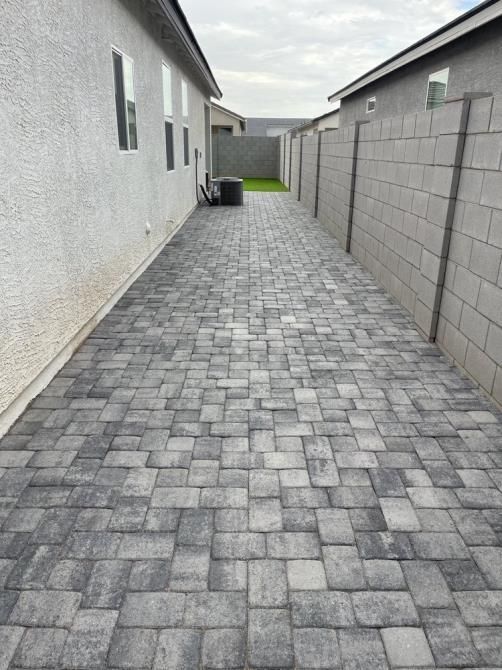 There is a brick walkway between two houses.