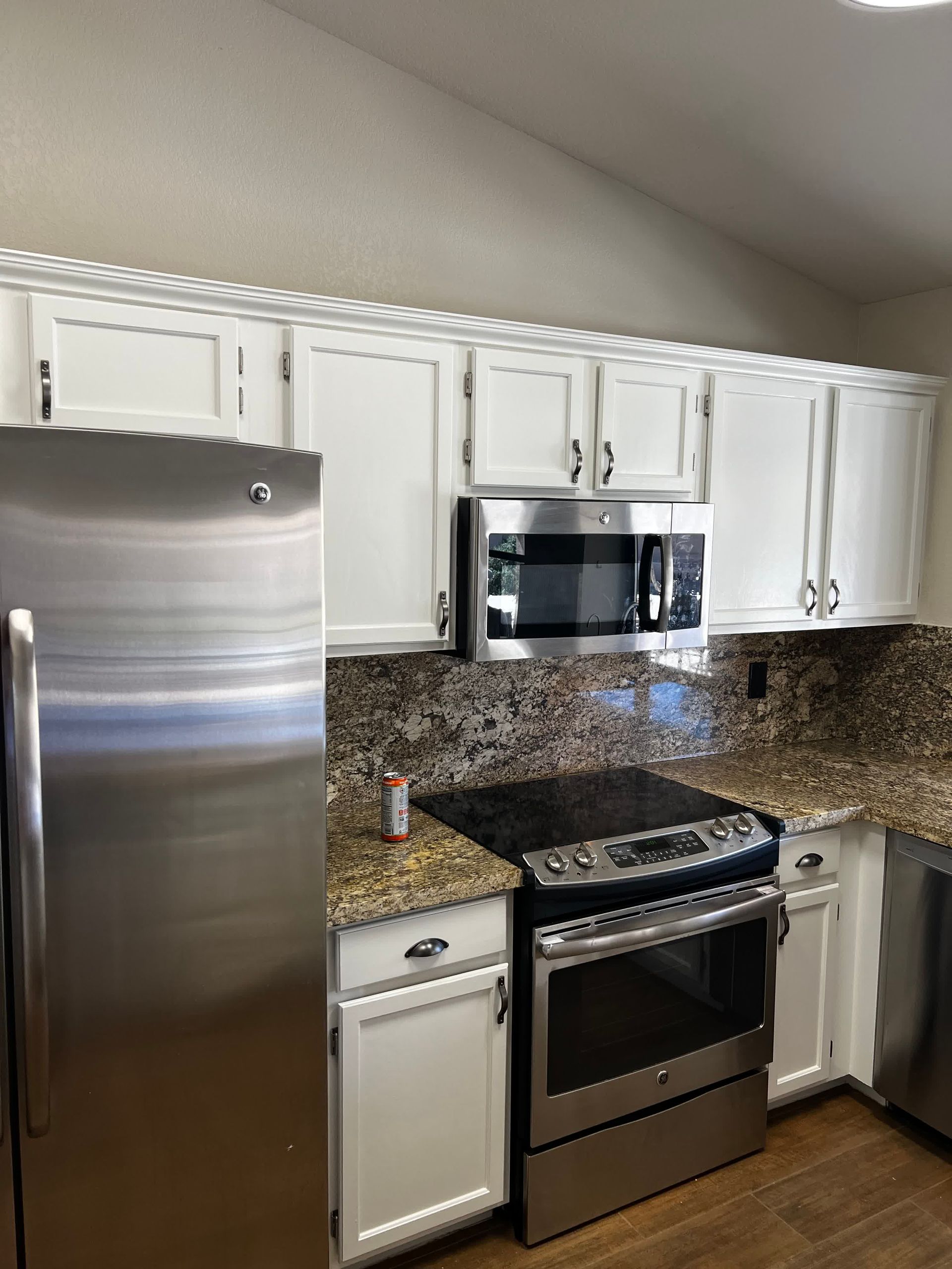 A kitchen with stainless steel appliances and white cabinets