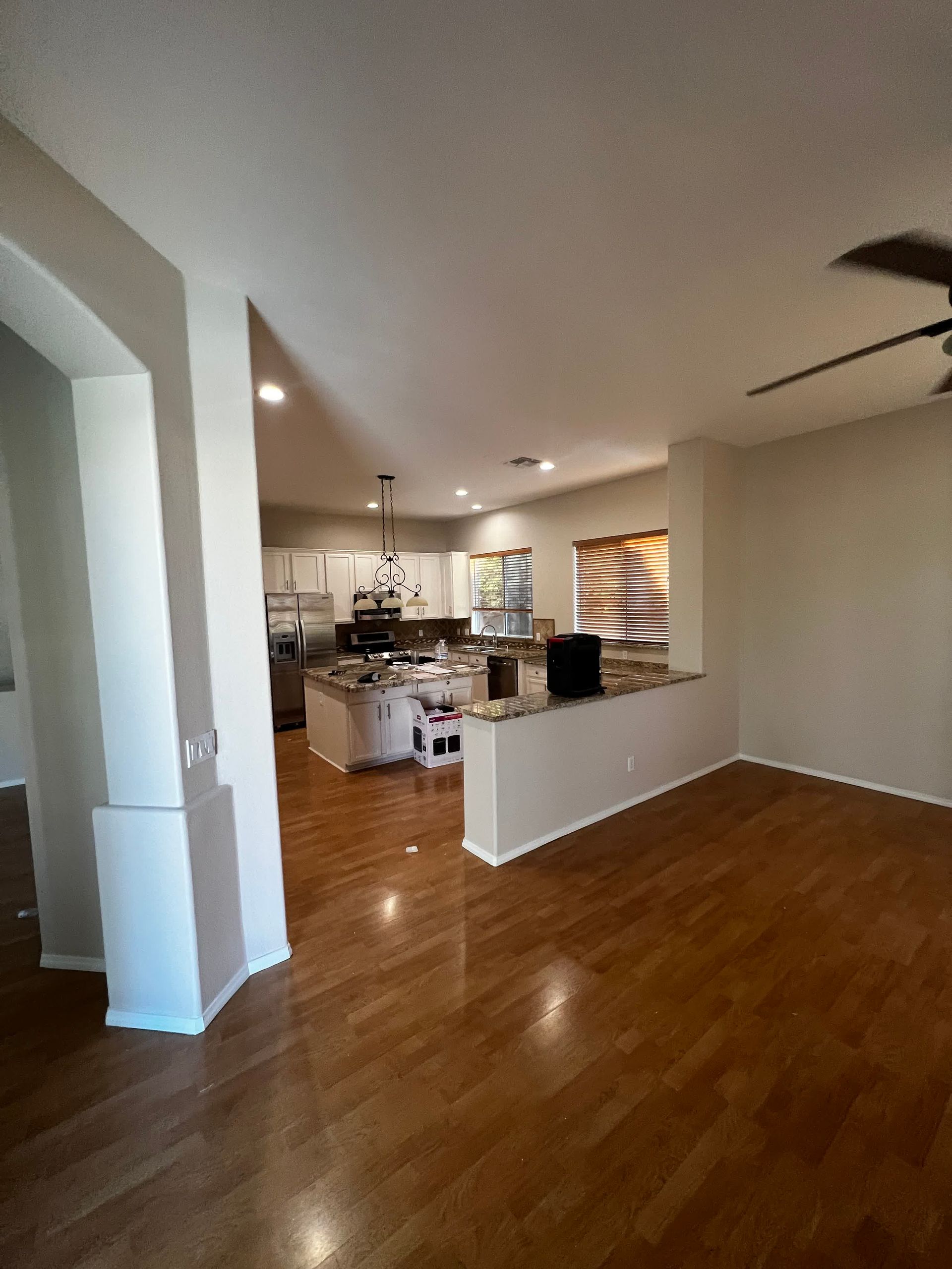 A living room with hardwood floors and a ceiling fan