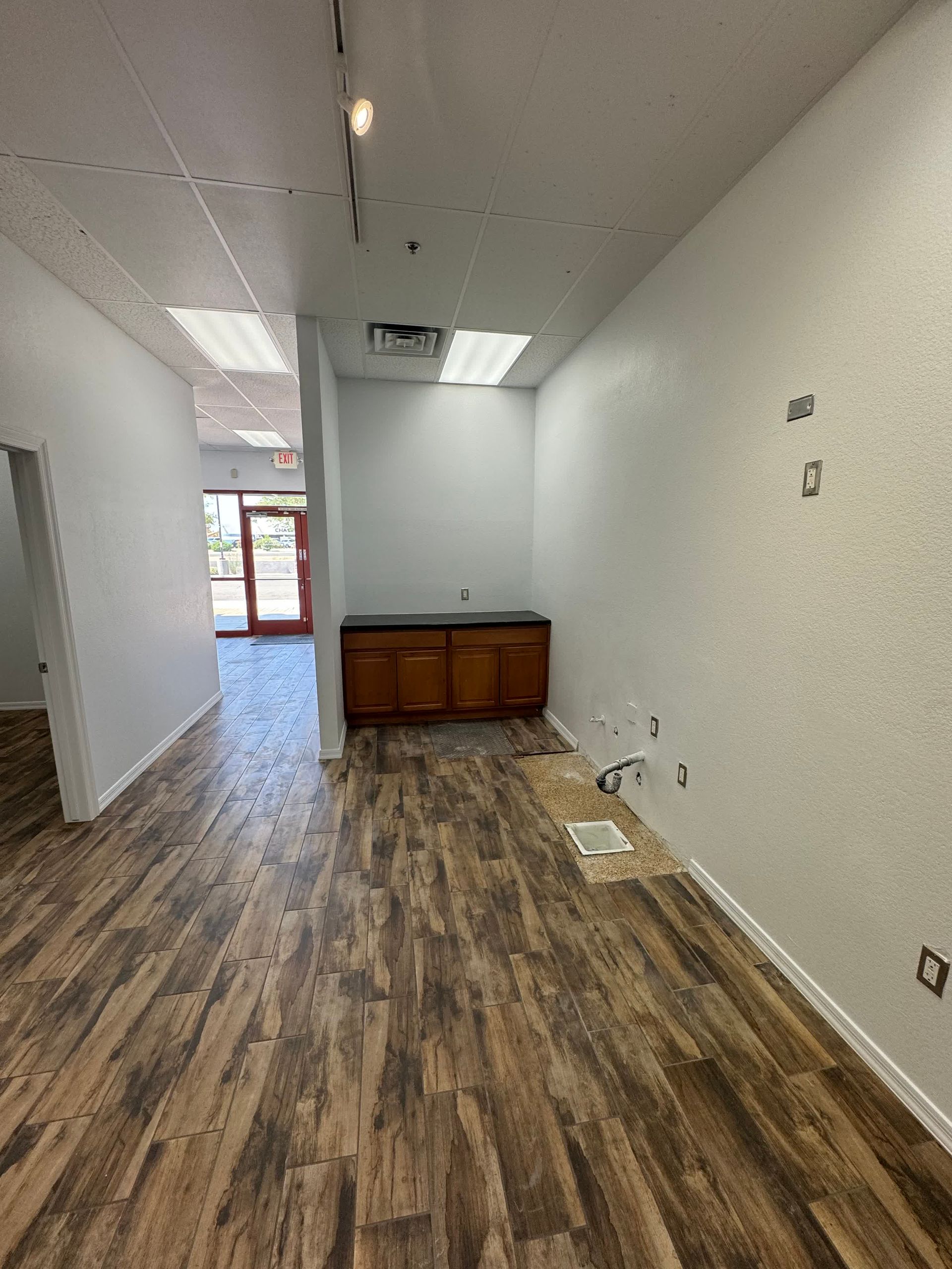 An empty room with wooden floors and white walls.