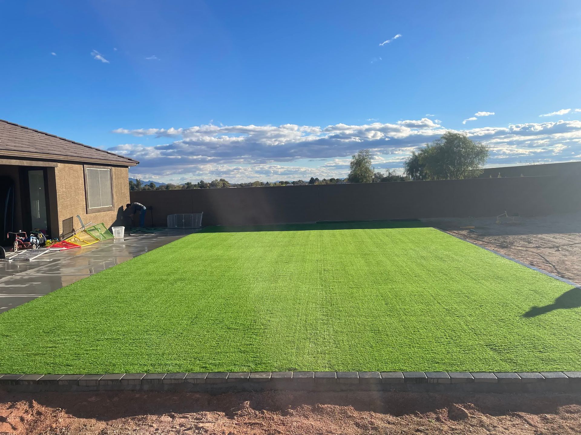 There is a large lawn in the backyard of a house.
