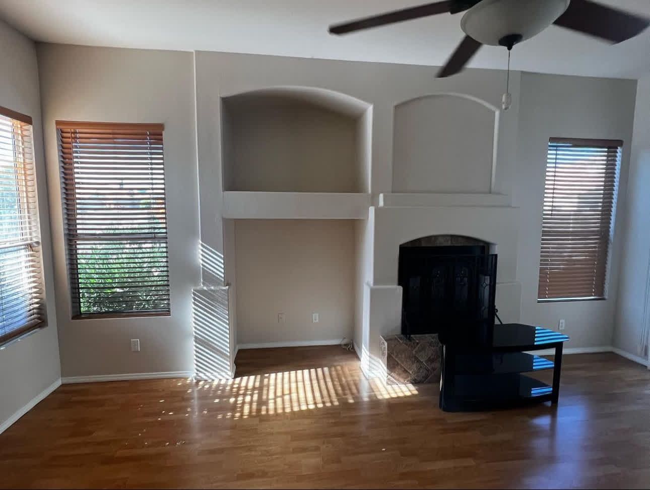 A living room with a fireplace and a ceiling fan