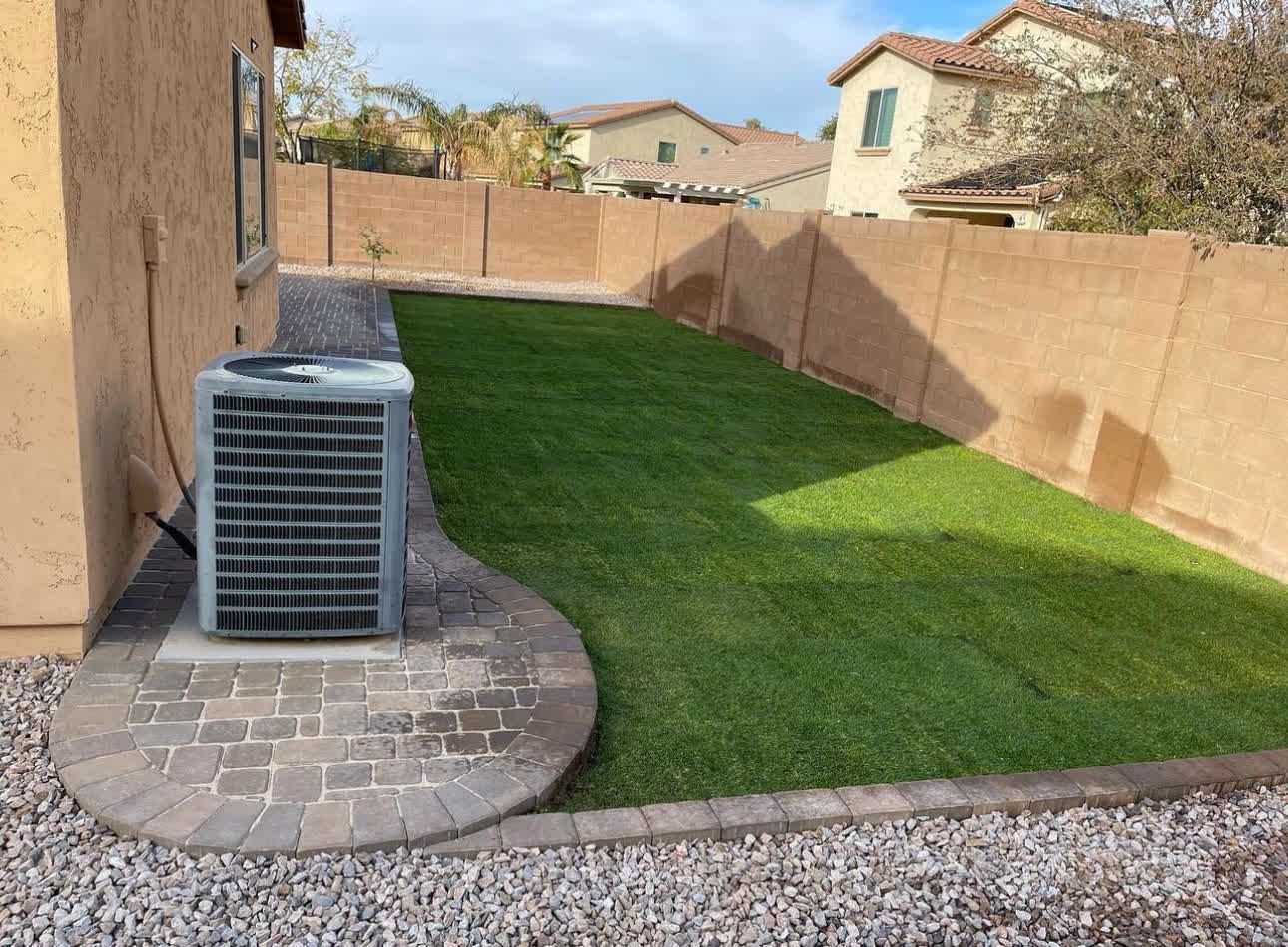 A backyard with a patio and a lawn air conditioner.