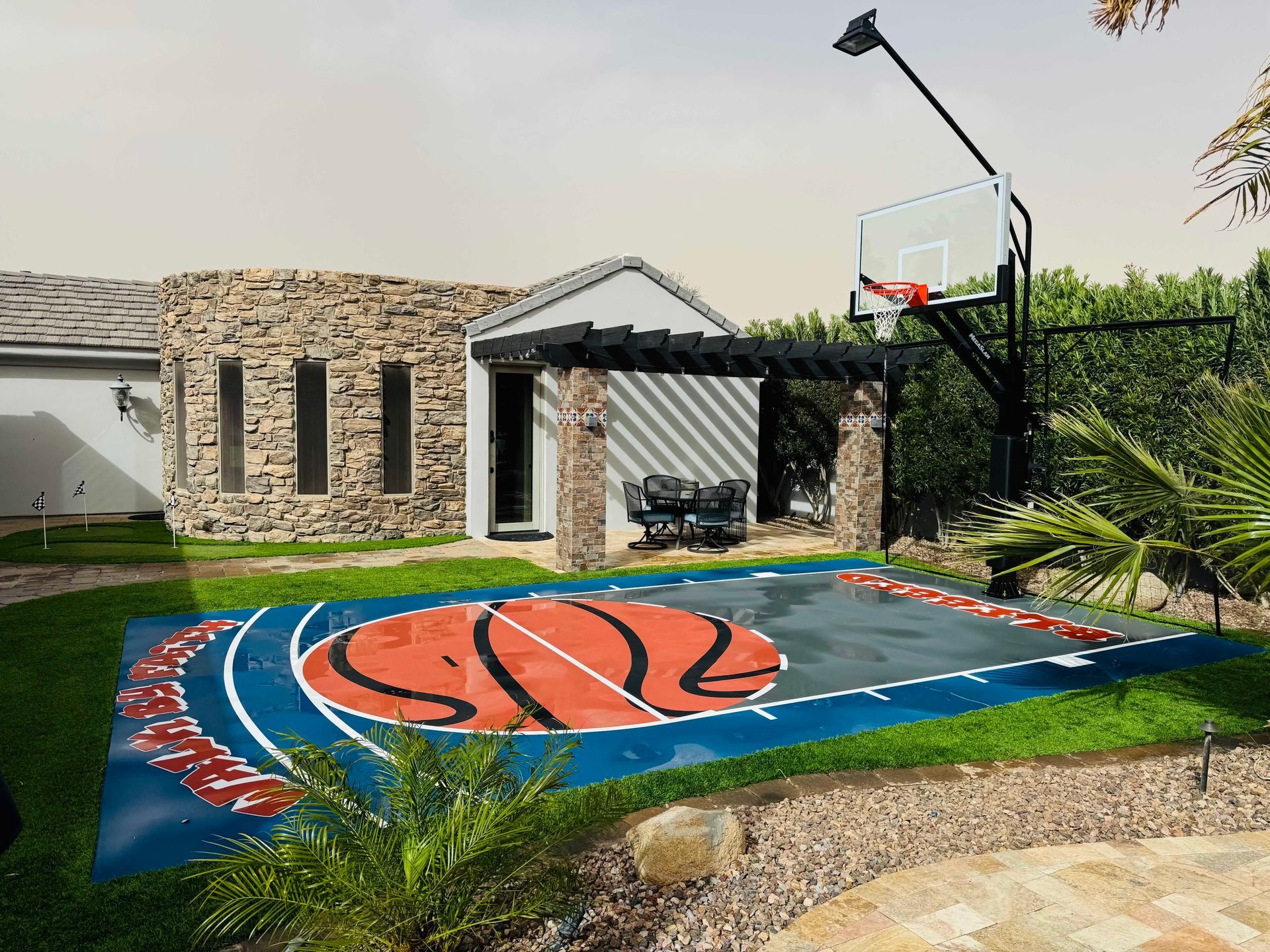 A basketball court in the backyard of a house