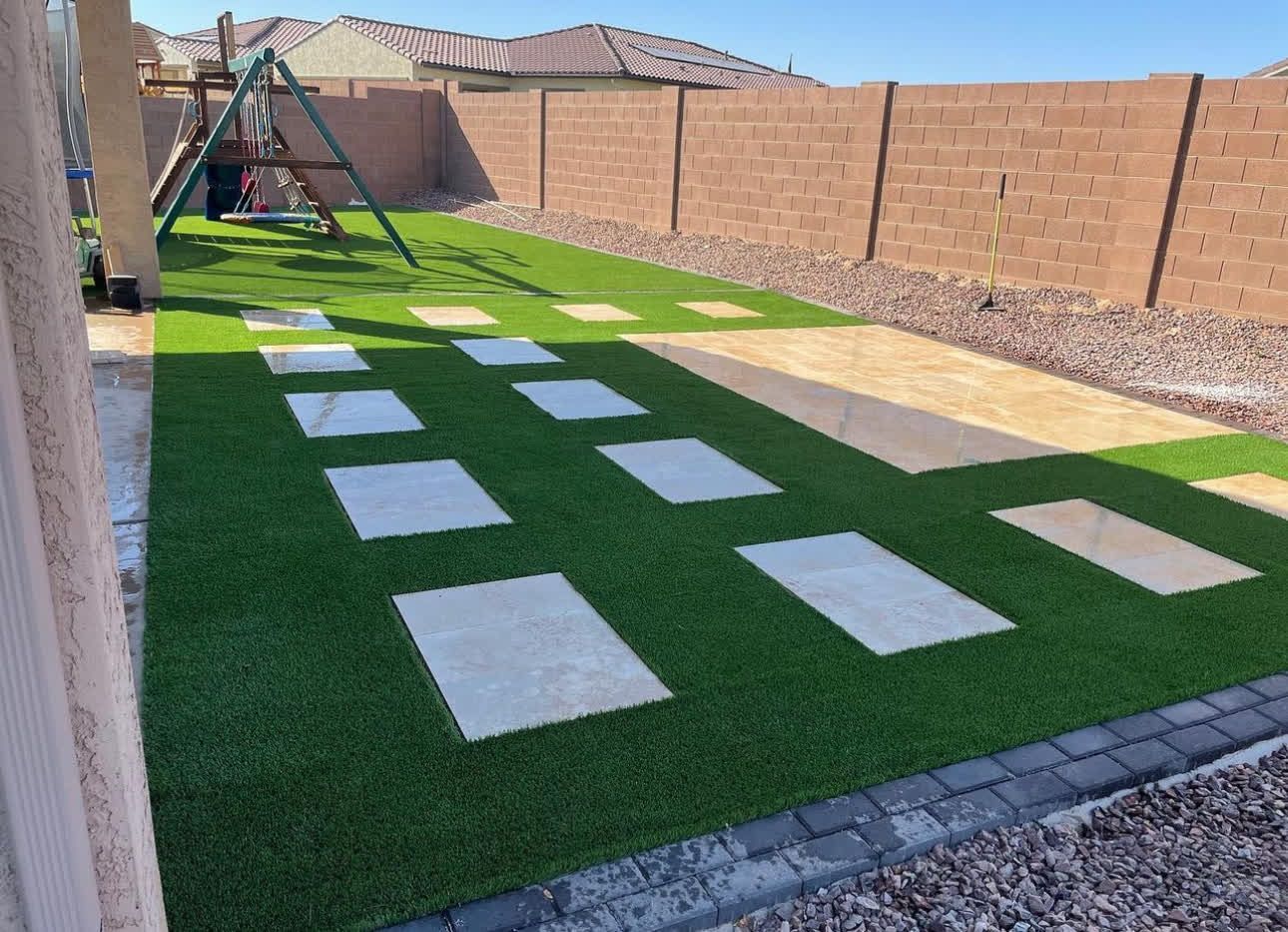 There is a playground in the backyard with a swing set and stepping stones.