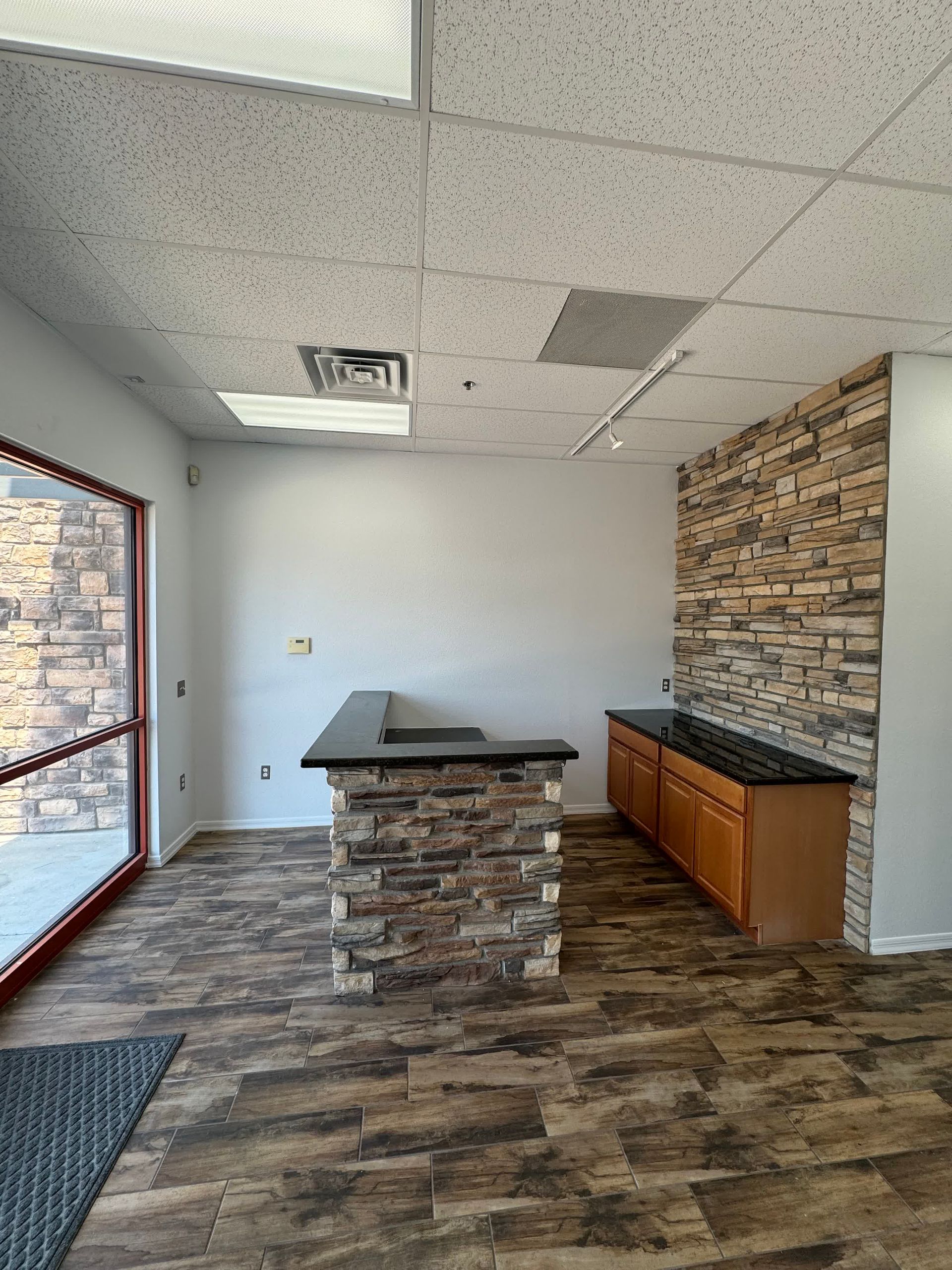 An empty room with a stone wall and a counter.