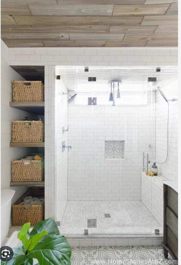 A bathroom with a walk in shower and wicker baskets.