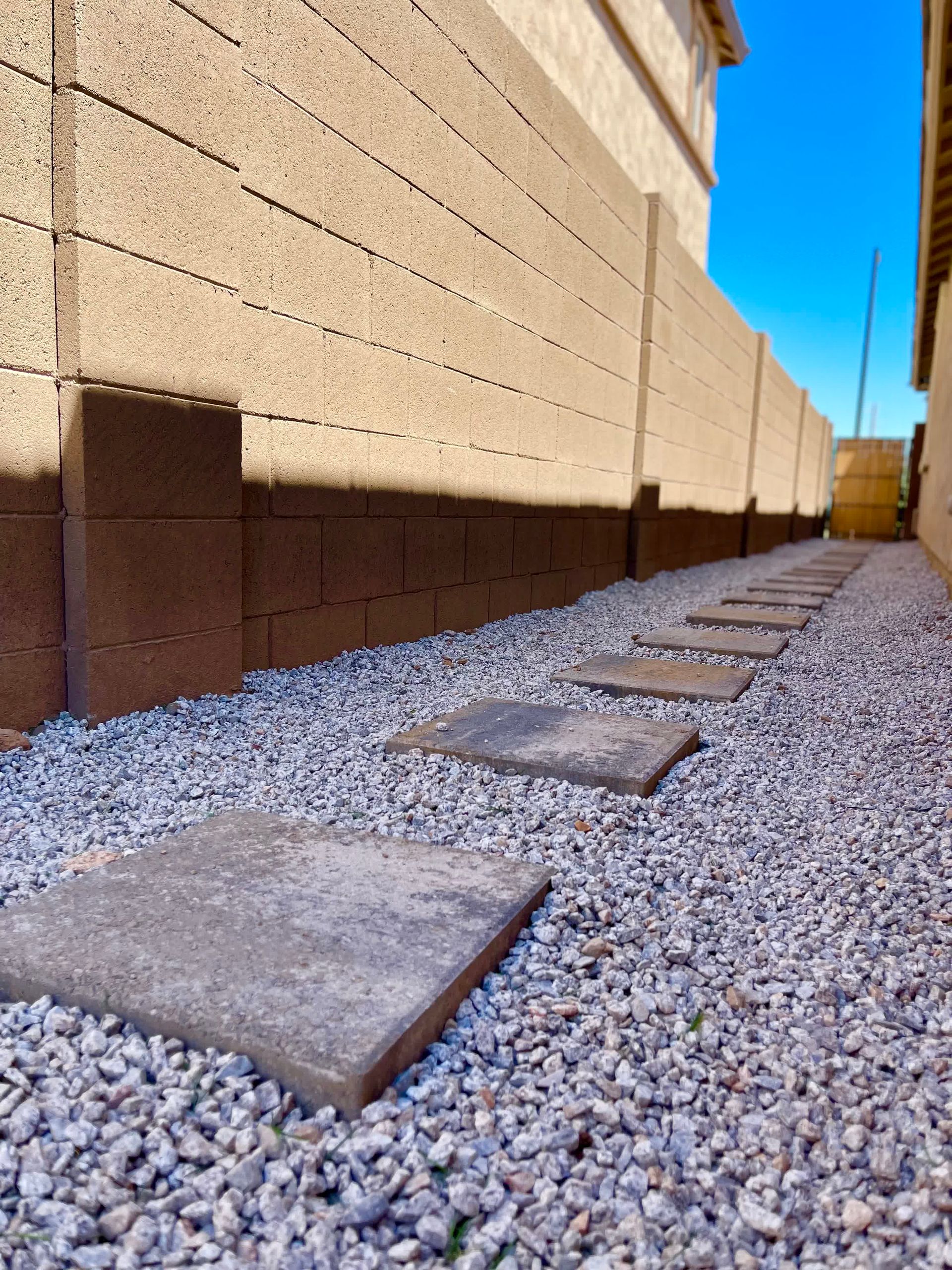 A walkway with gravel and bricks in front of a building