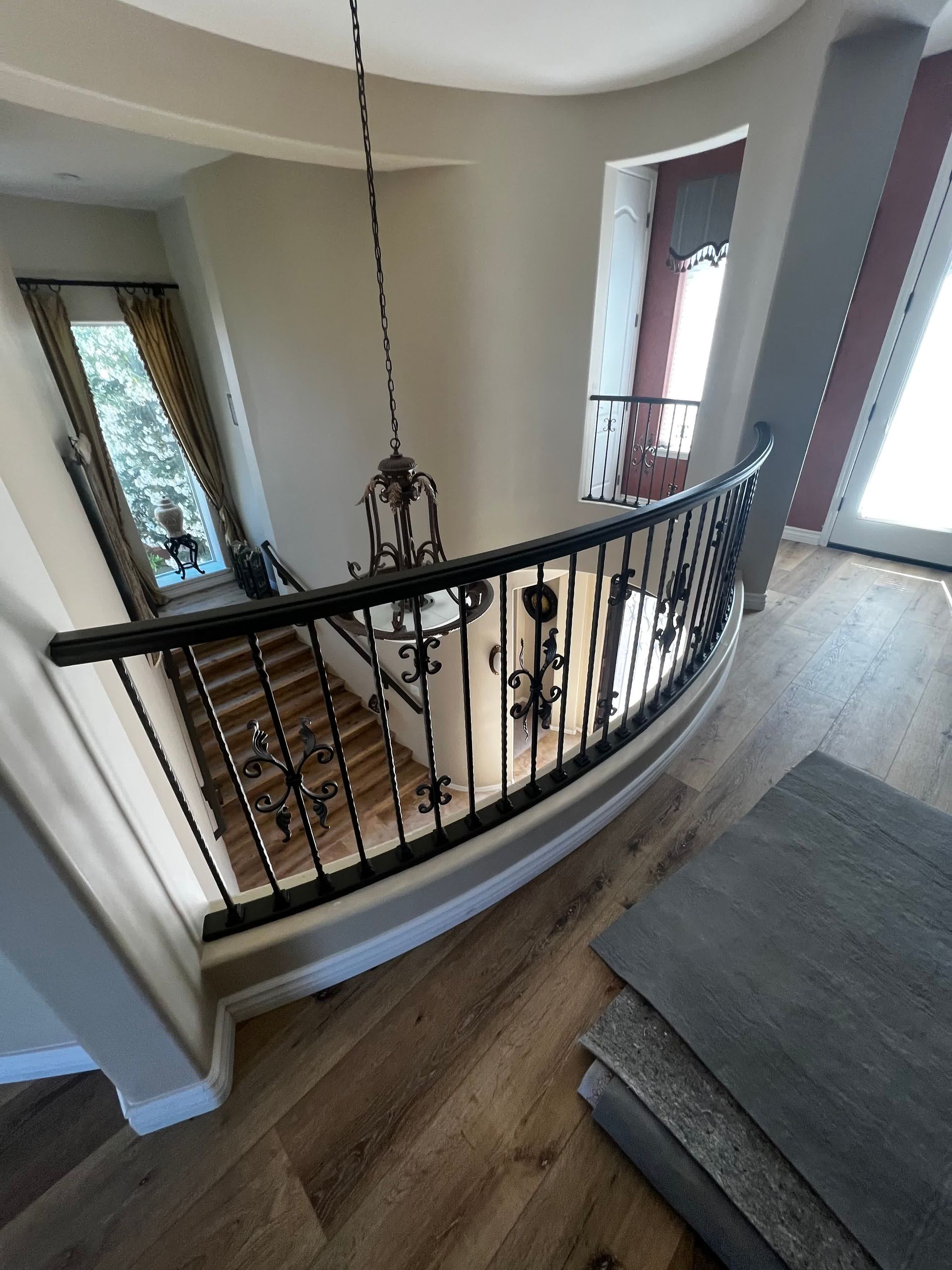 A staircase with a railing and a chandelier hanging from the ceiling