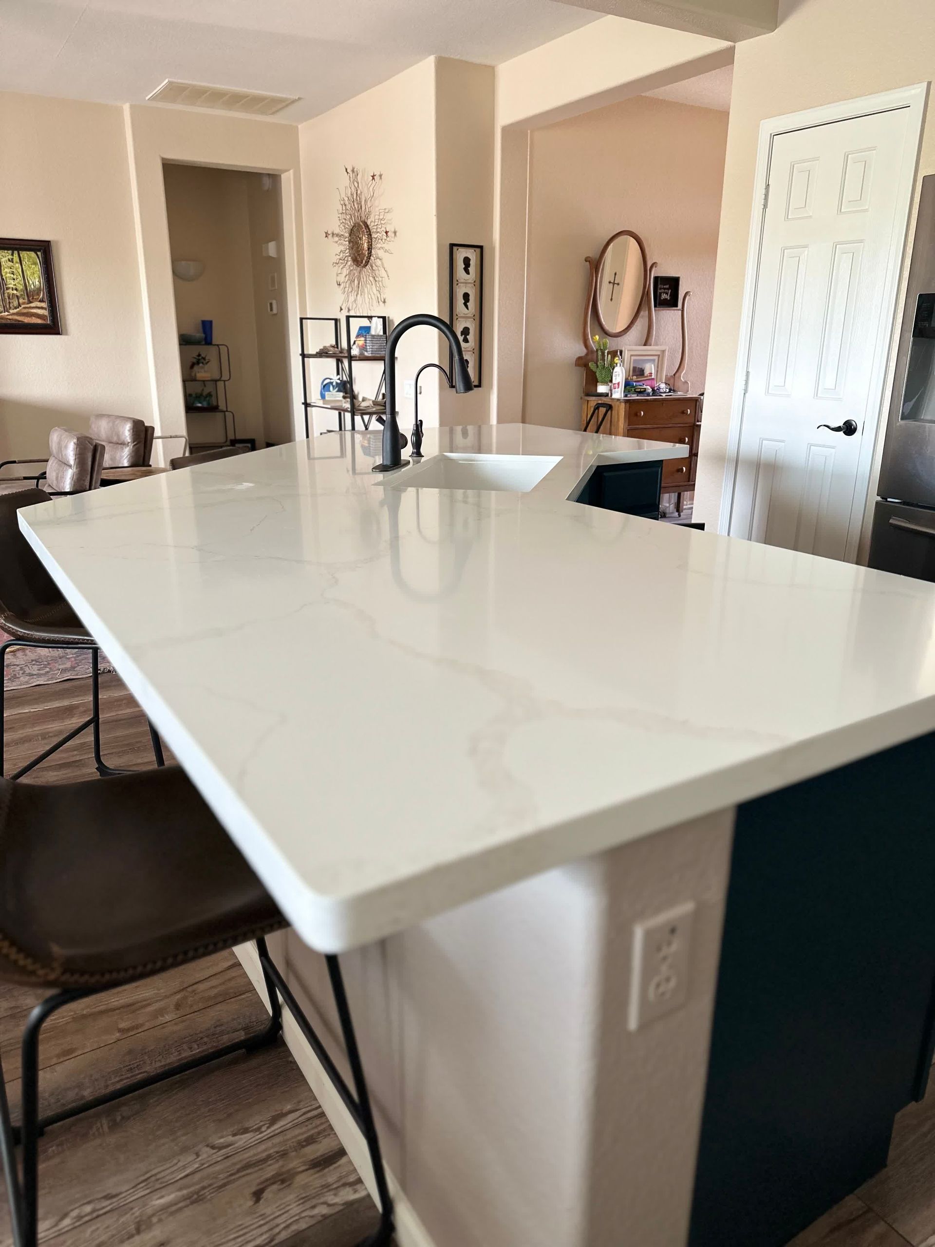 A kitchen with a large white counter top and a sink.