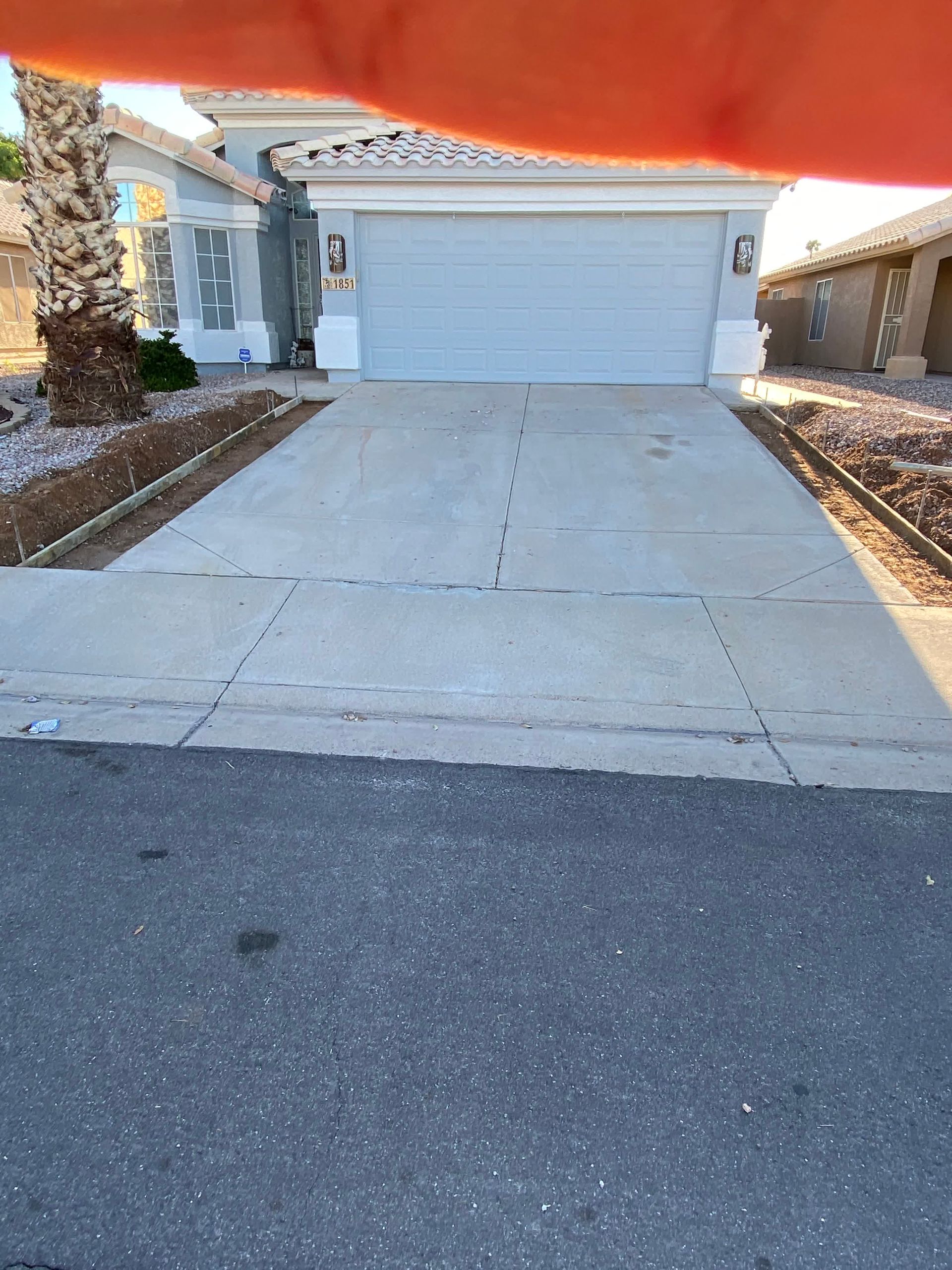 A person is holding a concrete driveway in front of a house.
