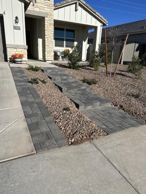 A brick walkway leading to a white house