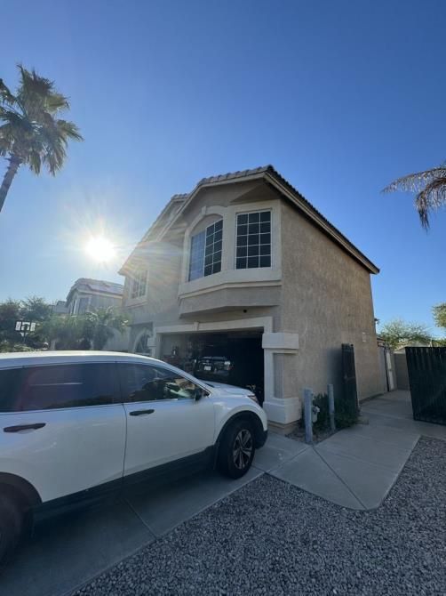 A white suv is parked in front of a house.