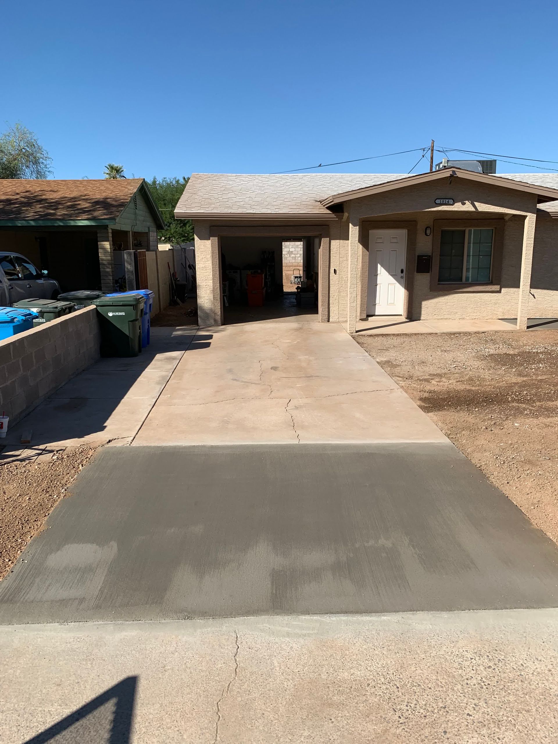 A concrete driveway is being built in front of a house.