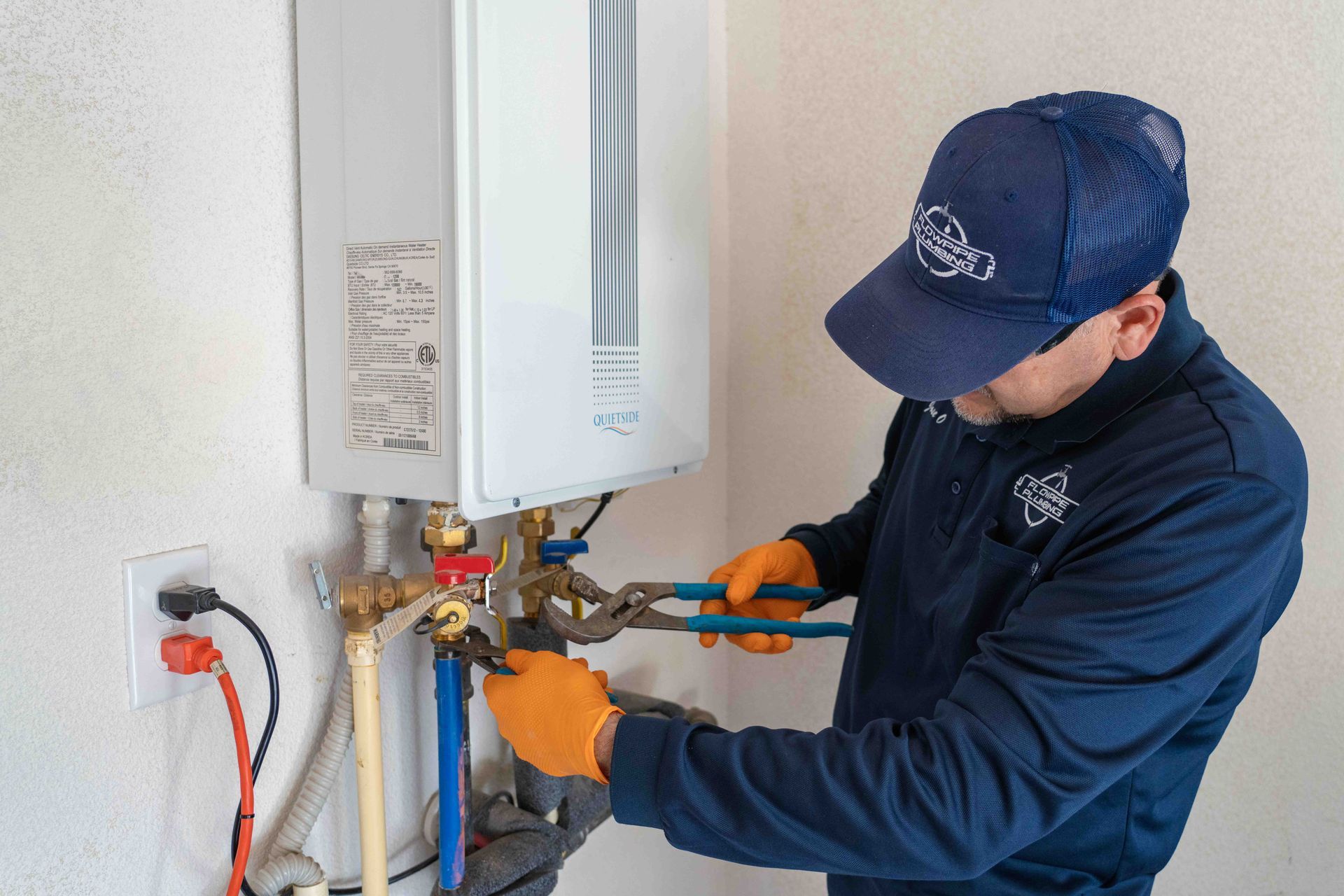 A man is working on a water heater in a room.