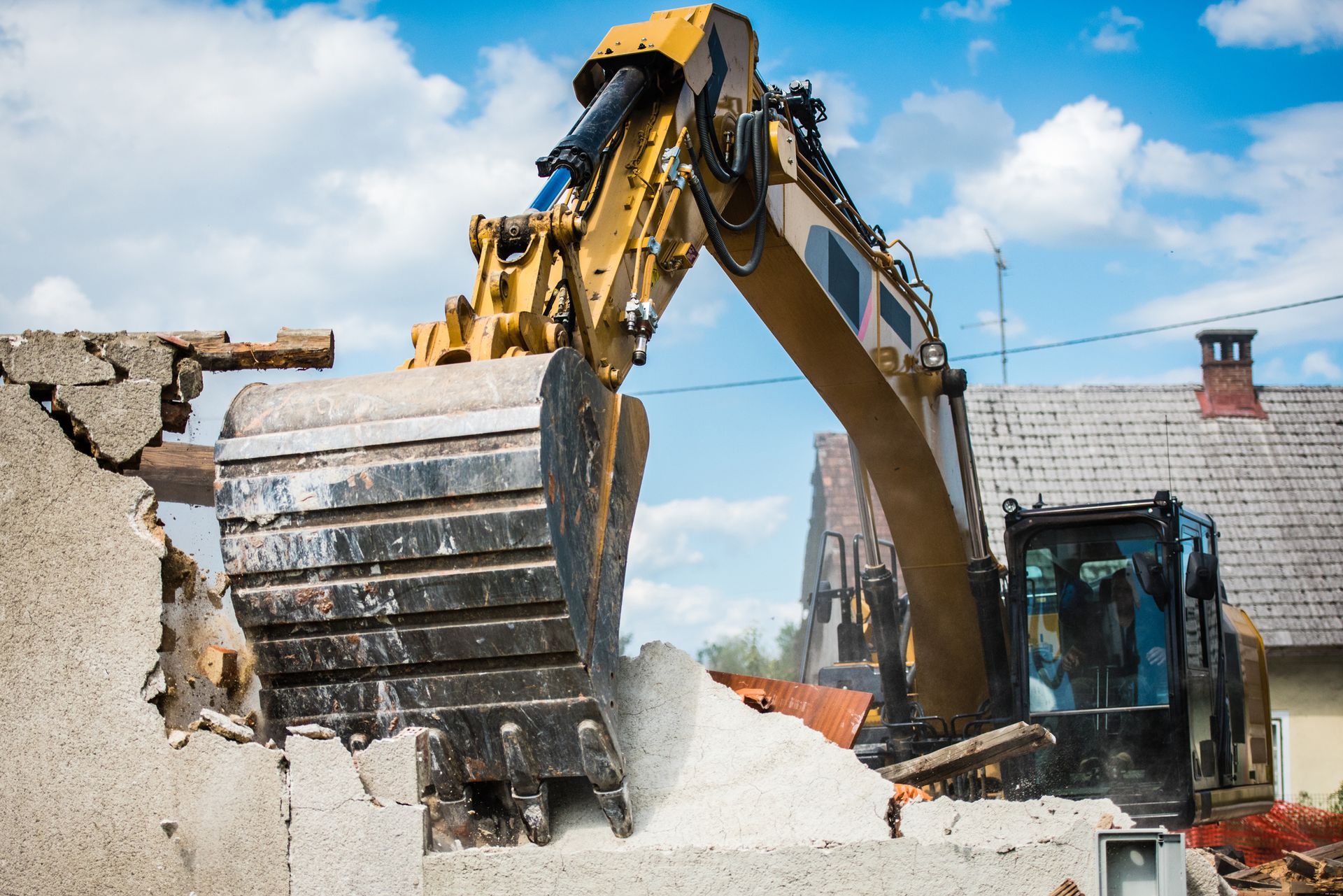 A bulldozer is demolishing a building on a construction site.