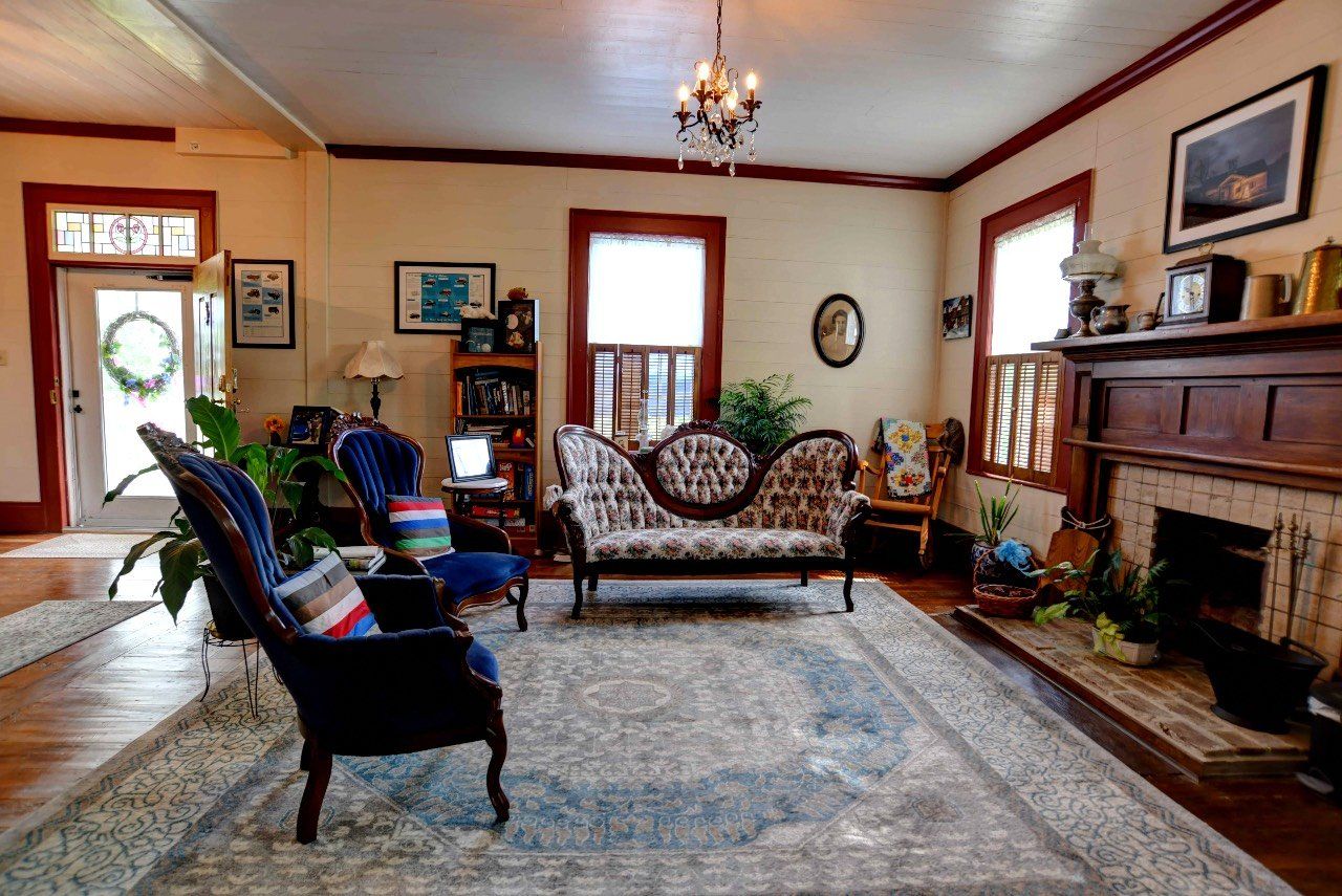 A living room with a couch , chairs , and a fireplace.