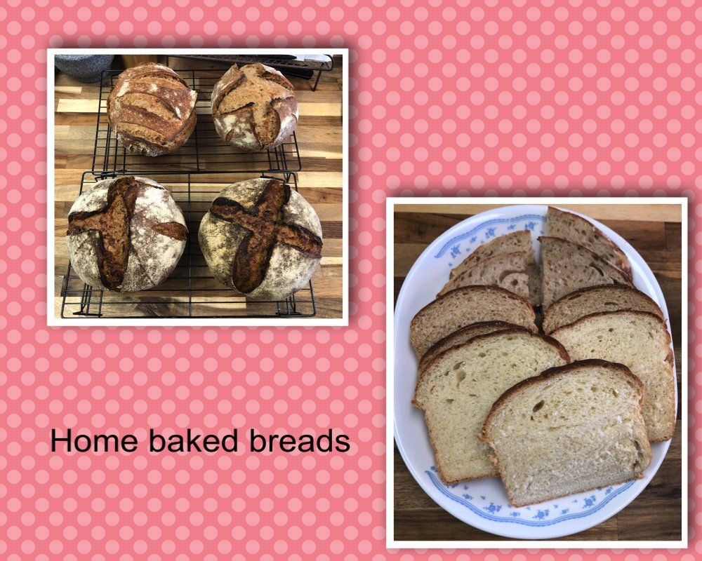 Two loaves of bread are sitting on a cooling rack next to a plate of sliced bread.