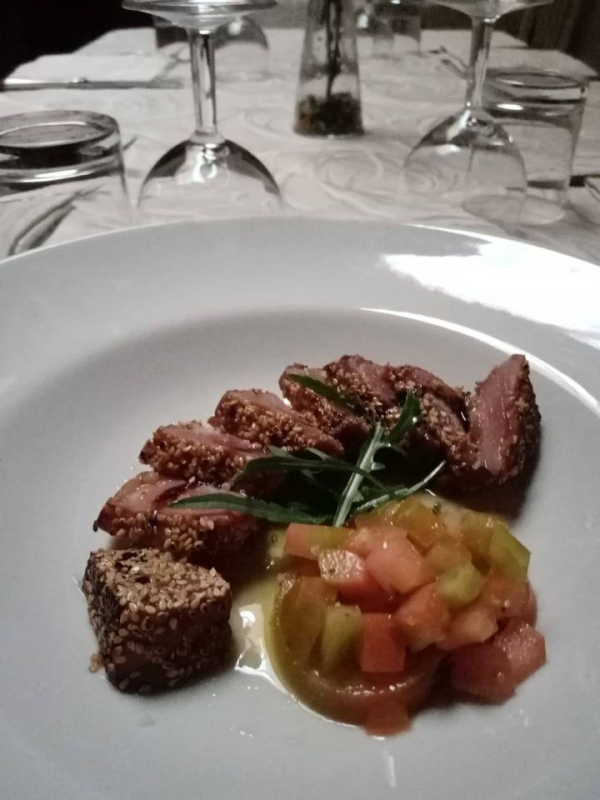 Piatto di cibo: carne scottata, salsa di pomodoro e un quadrato di pane tostato.