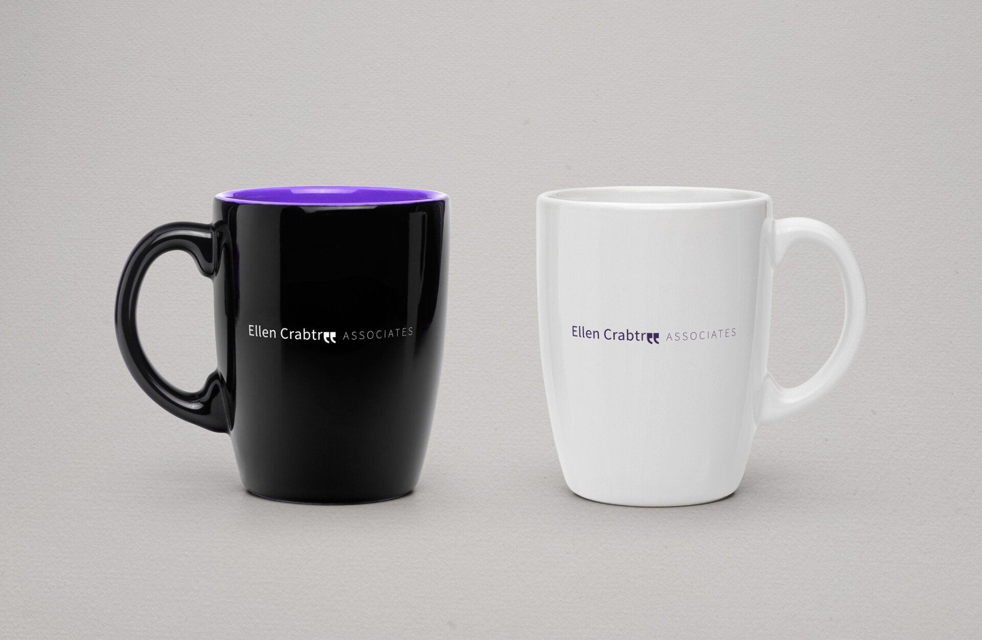 Two coffee mugs one black and one white are sitting next to each other