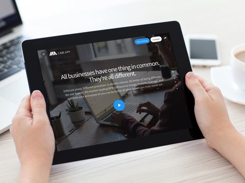 A person is holding a tablet with a website on it.