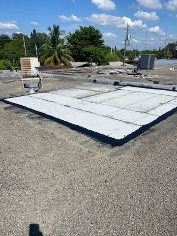 A Construction Worker Is Sitting On Top Of A Metal Roof — Miami, FL — ACN Roofing