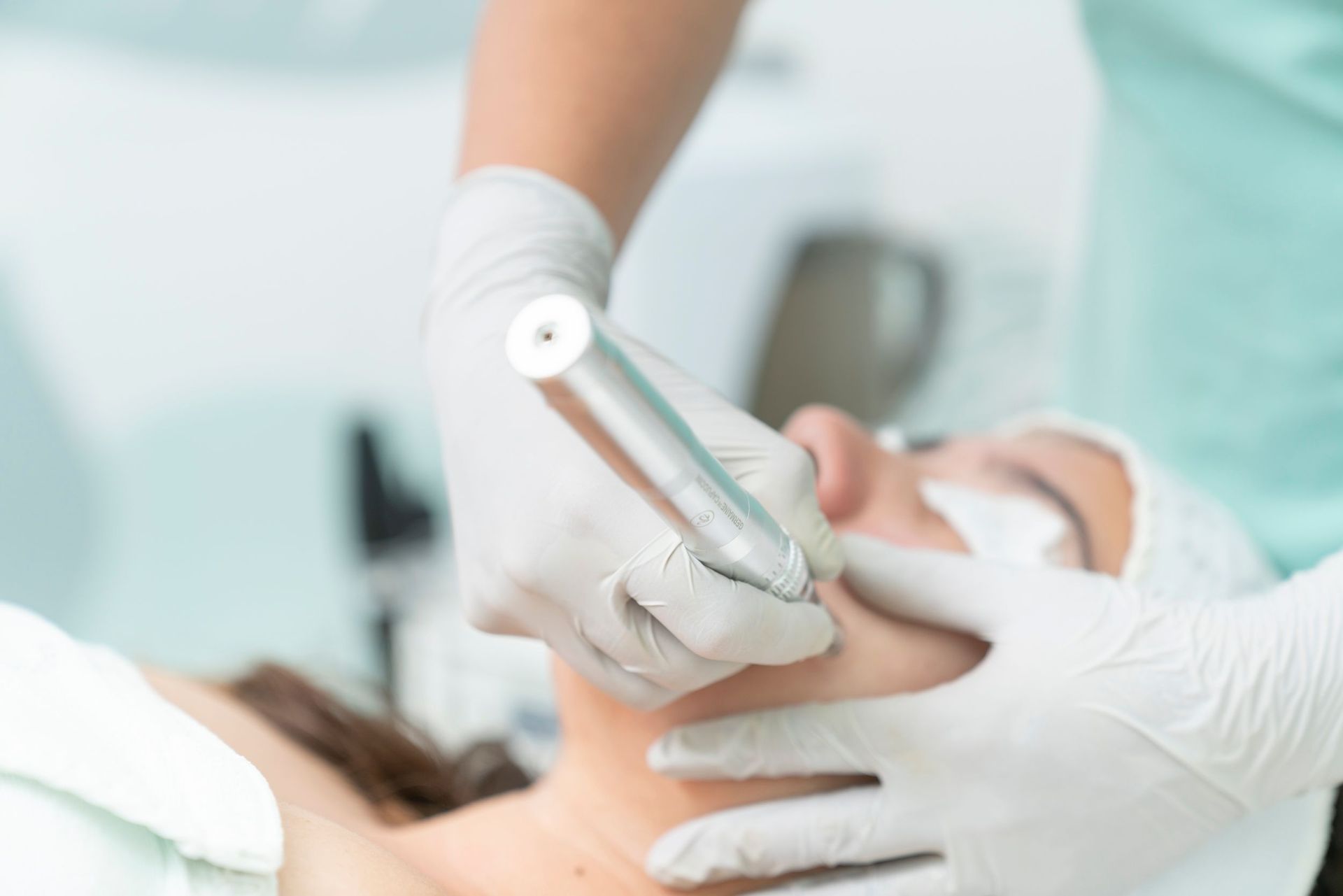 Dentist examining a patient’s mouth with a handheld tool in a clinical setting