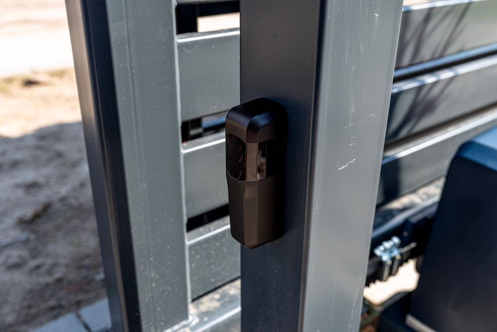 Close-up of a black gate latch on a gray metal fence outdoors. — KLS Fencing In Innisfail, QLD